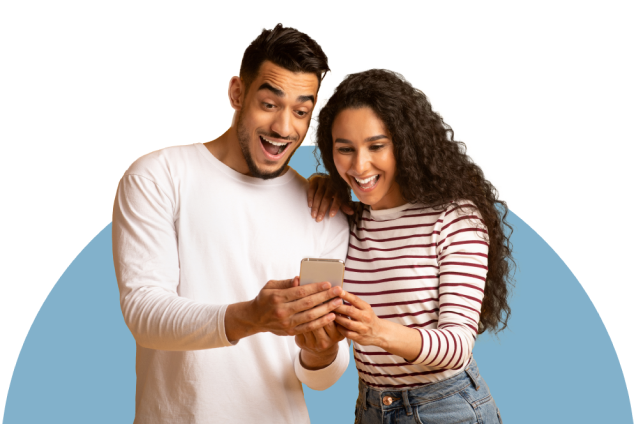 A happy couple smiling and looking at a phone